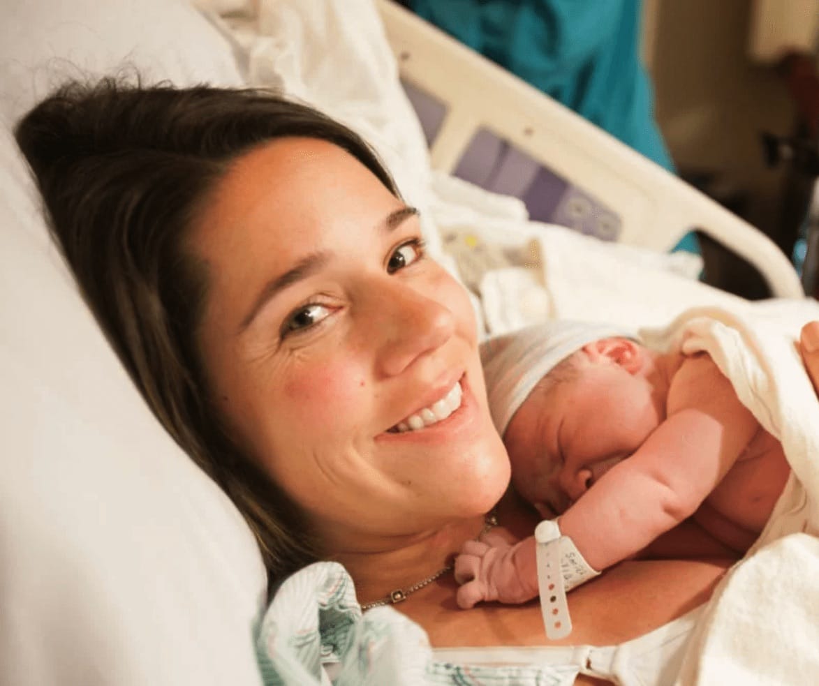 Happy woman in hospital bed with newborn child